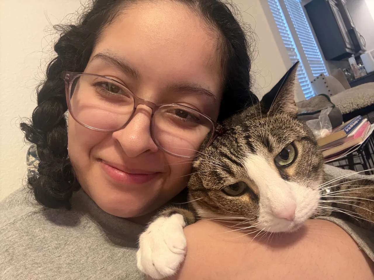 Jessie smiling with a tabby cat on her shoulder